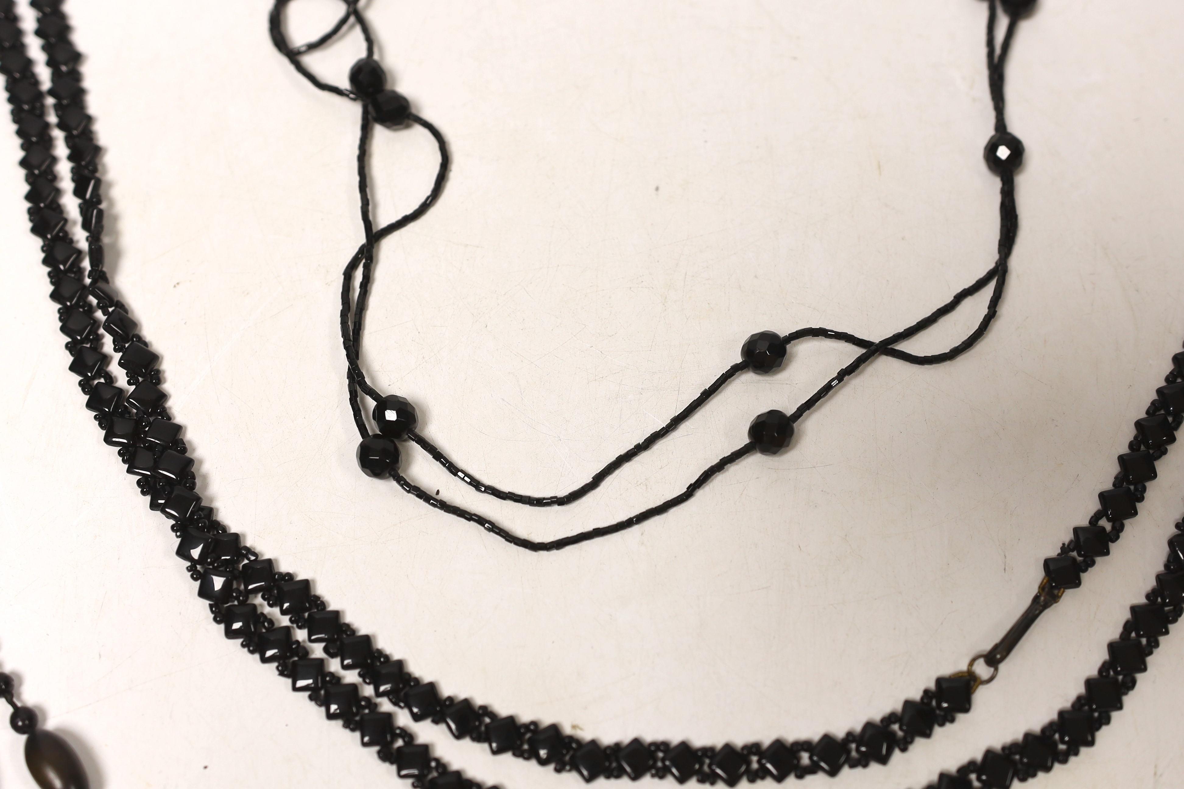 Three assorted necklaces including Whitby jet, largest 162cm.